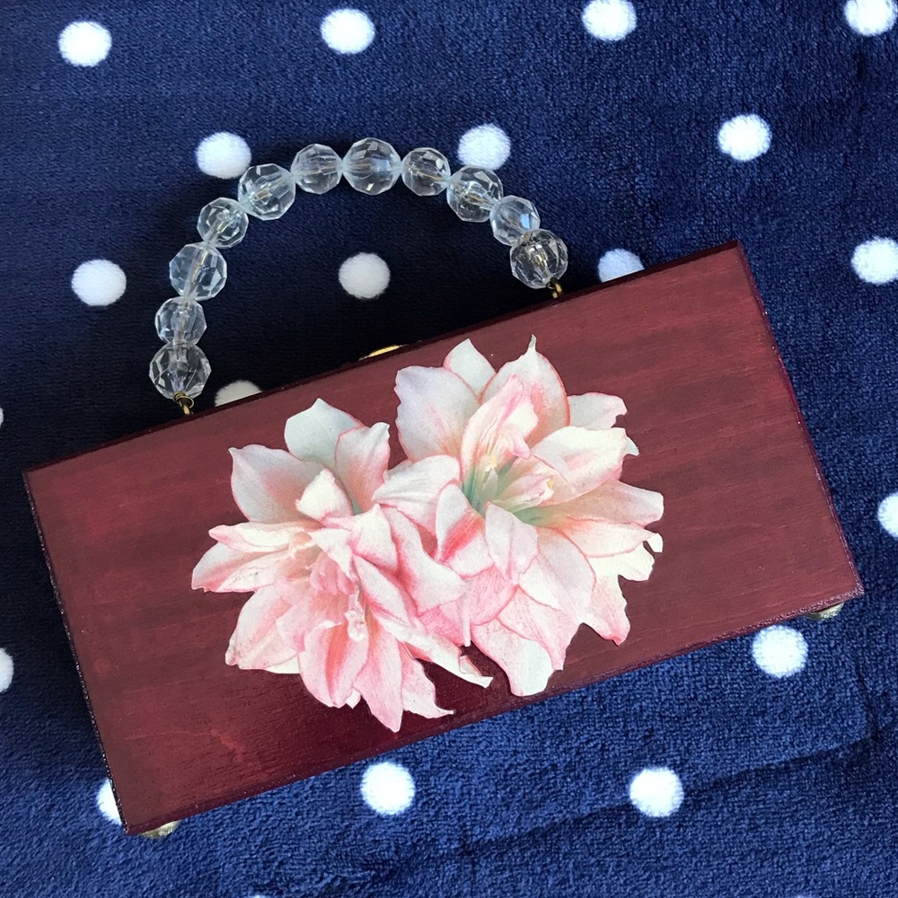 Unique wooden purse with beaded handle and flower appliqué on front.